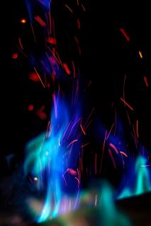 A blue flame emitting red sparks