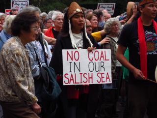 Protesters gather around a sign reading, "No Coal in our Salish Sea".