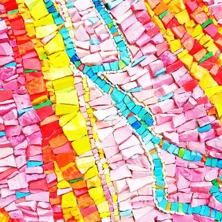 A close-up on the detail of a mosaic, with vivid lines of pink, yellow. and blue chips.