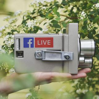 Vintage movie camera with Facebook logo and the word "live" on a decal