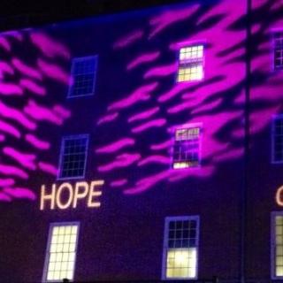 UU Value words, Love, Justice, Hope, Faith and Community, projected on to a building for light show.