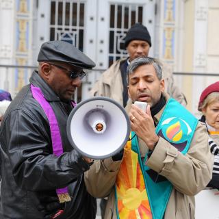 Rev. Manish Mishra-Marzetti leads prayer with a bullhorn at a Black Lives Matter event.