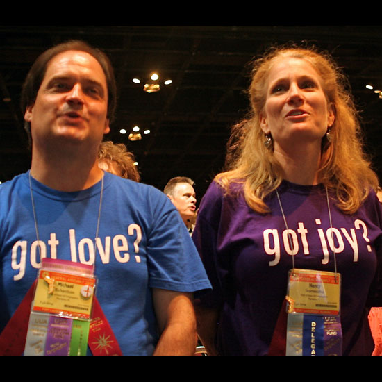 Two UUs enjoy the GA Opening Ceremony; one is wearing a shirt that asks, 'got love?' and the other a shirt that reads, 'got joy?' Photo by Helio Fred Garcia.