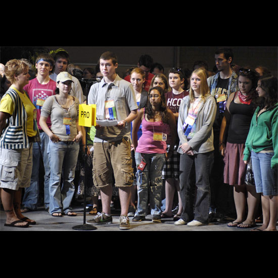 Youth stand at the 'Pro' microphone during a Plenary debate, ready to make their case. Photo by Nancy Pierce.
