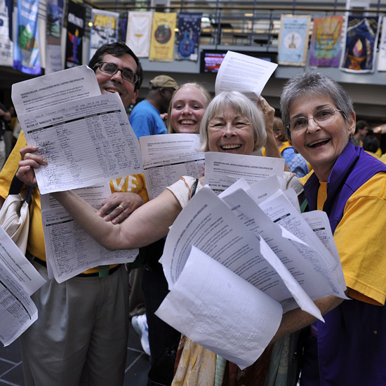 Delegates display the pages of signatures they've collected in support of their Action of Immediate Witness. Photo by Nancy Pierce.