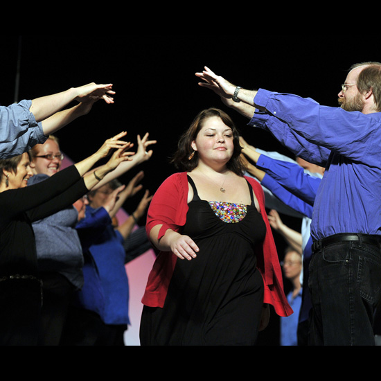 During the Syngergy Bridging Worship, participants passed beneath an archway formed by two lines of facing adults, symbolizing the transition from youth to young adulthood. Photo by Nancy Pierce.