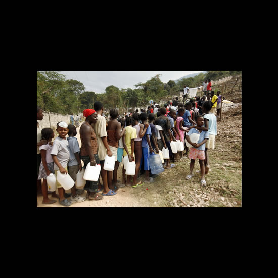 Haitians queue for water in Tapis Rouge, a neighbourhood in the Carrefour-Feuilles area of Haiti's capital city, Port-au-Prince. Carrefour-Feuilles, a slum that stretches into the high mountains surrounding the city, has received little assistance since Haiti's earthquake. mage courtesy of Sophia Paris via the United Nations Photo Library.