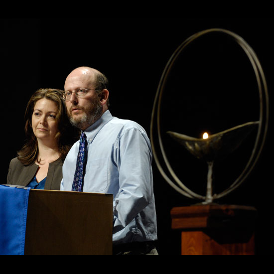 Mitra Jafarzadeh and Chris Buice standing together at a podium, a chalice in the foreground. Photo by Nancy Pierce.