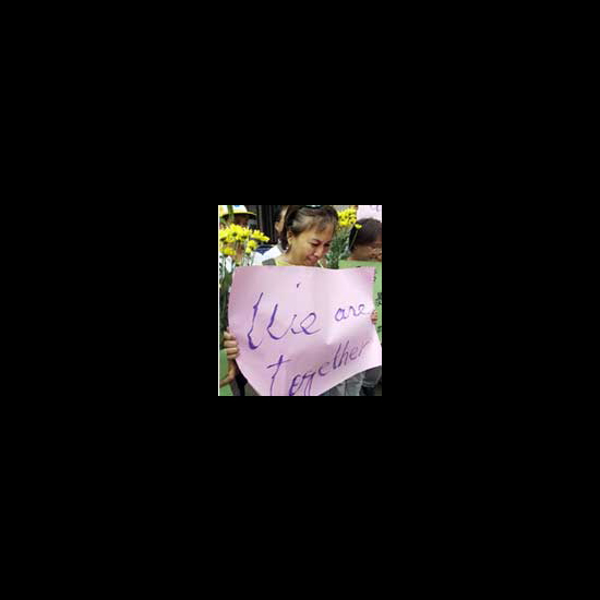 Woman in Taiwan holds a sign reading, 'We are Together.' 