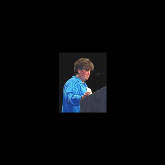 Meg Riley speaking at a podium. 