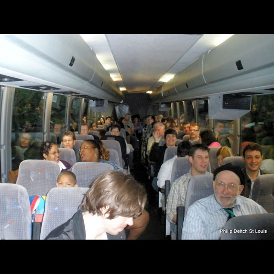 A group of people smile from their bus seats. Photo by Philip Deitch.