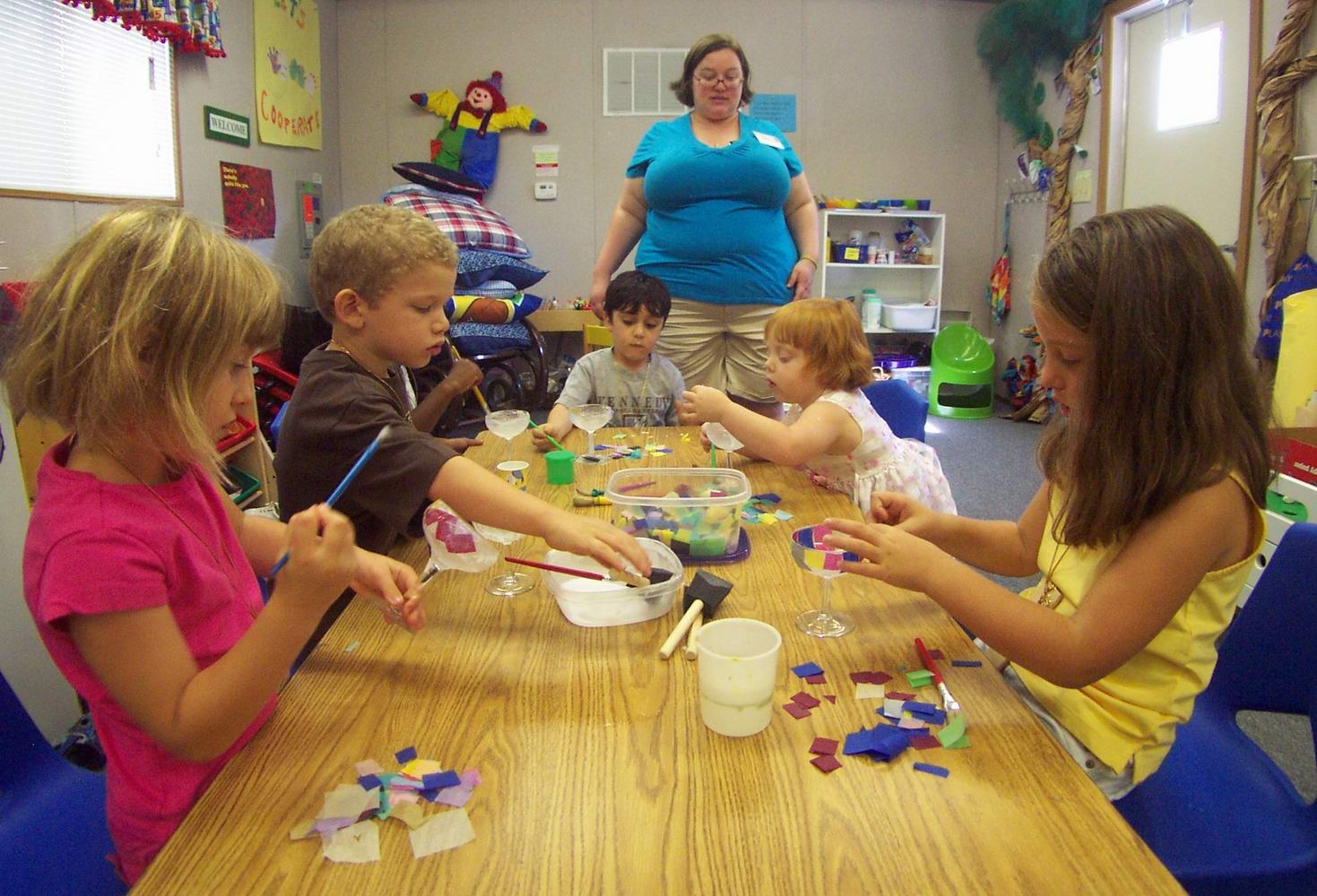 Teacher with young children making chalices.