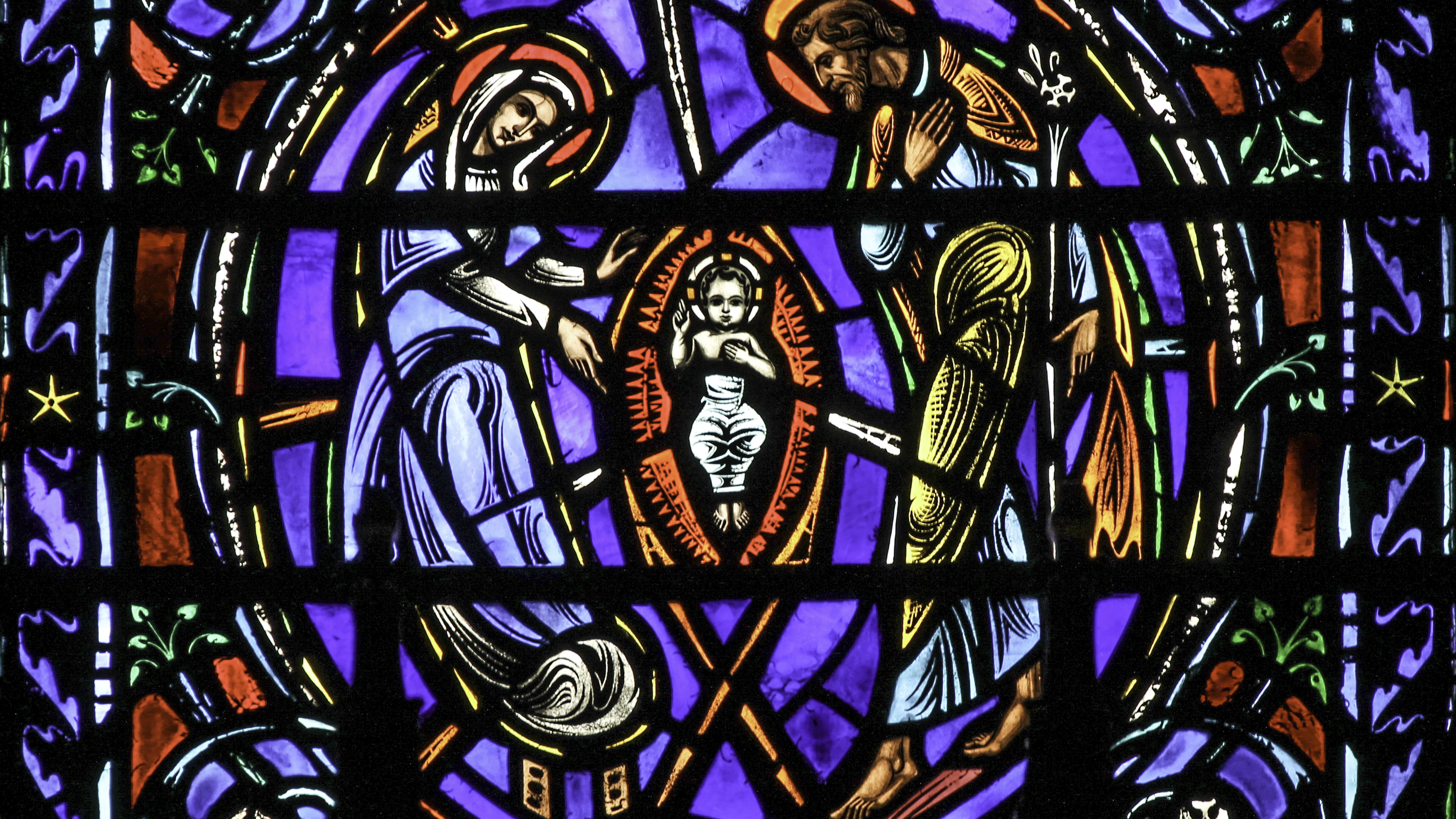 Stained glass detail from the Dominican church of St Vincent Ferrer in New York, showing Jesus in a manger surrounded by Mary and Joseph.