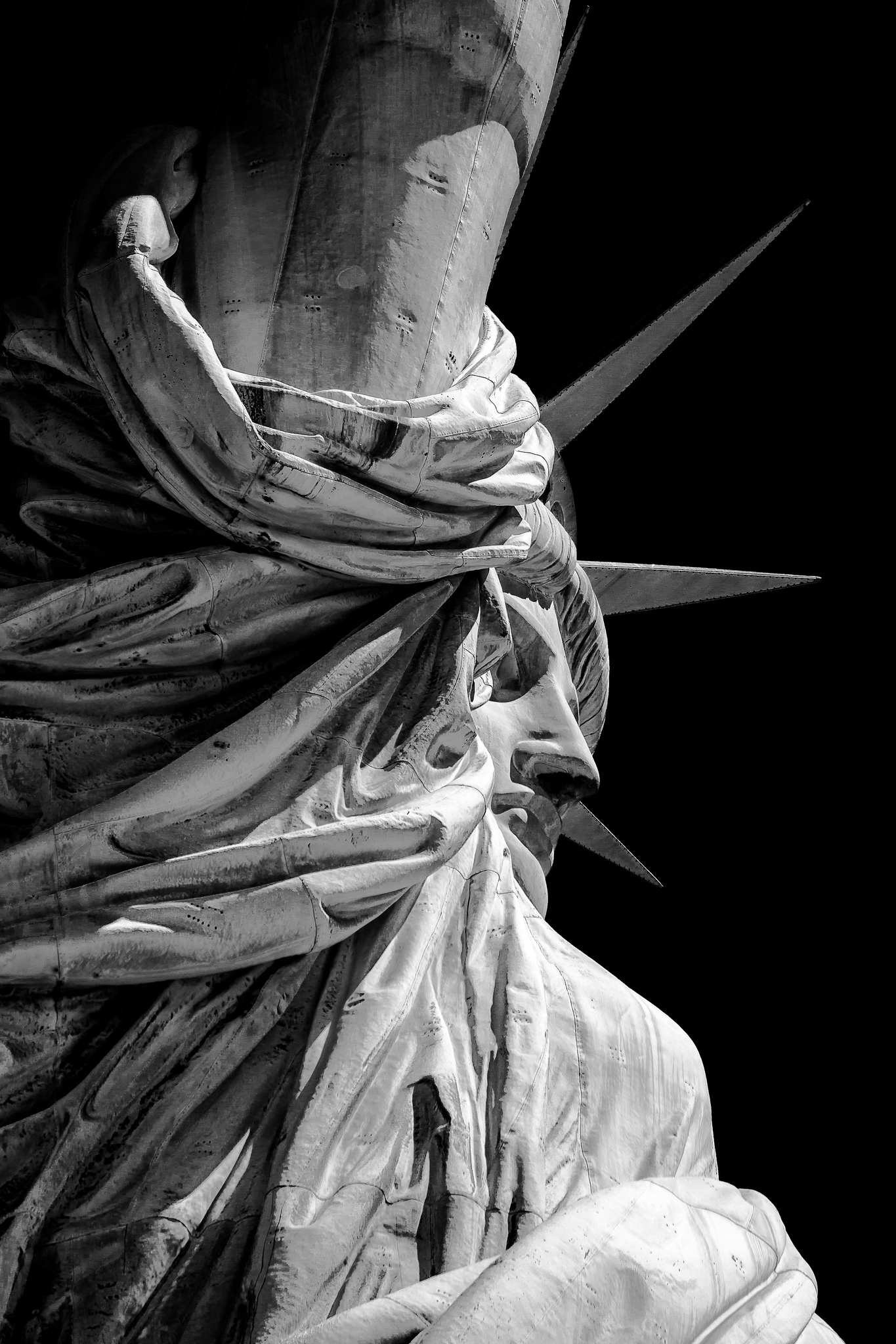 A black-and-white close-up of the face of the Statue of Liberty