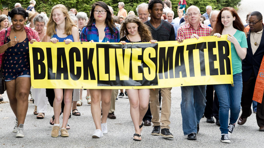 UU Annapolis Youth lead a marching crowd carrying Black Lives Matter Banner