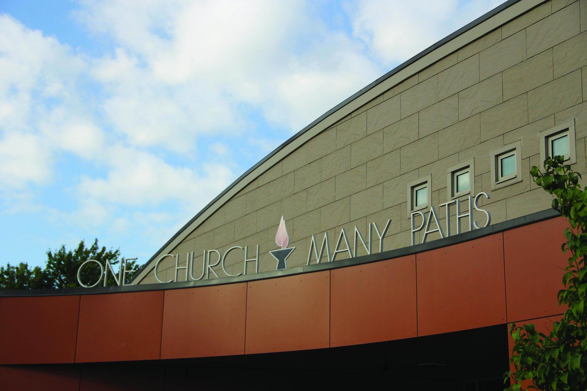 church building with sign, "One Church, Many Paths"