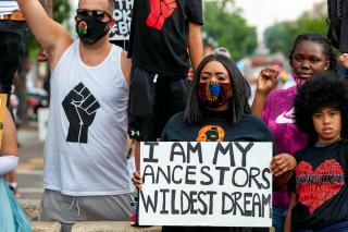 Washington, DC, USA - June 19, 2020: A young protester and celebrant of Juneteenth holds a sign that reads "I am my ancestors' wildest dream" at Black Lives Matter Plaza / Lafayette Square