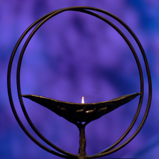 The lit GA chalice with a round frame. Behind it is a purple textured background.