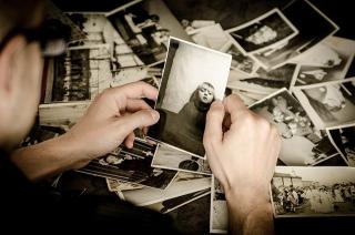 Person sorting through a pile of old photographs