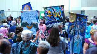 People carrying congregational banners into the General Session Hall at the 2015 GA.