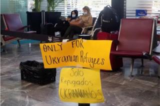 A sign in an airport reading "Only for Ukrainian Refugees / Solo Refugiados Ucranianos"