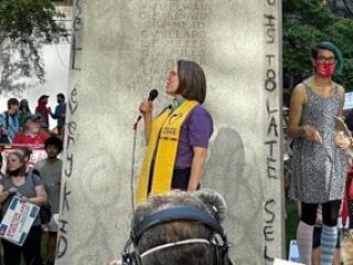 side view of Rev. Susan Frederick-Gray speaking outside at a rally