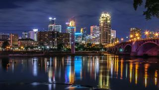Nighttime skyline of Minneapolis, with river in the foreground