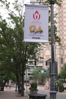 A lamp-post banner welcomes the UUA GA to Pittsburgh on Penn Avenue near the Convention Center