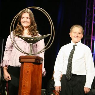 Two youth prepare to light the General Assembly chalice.