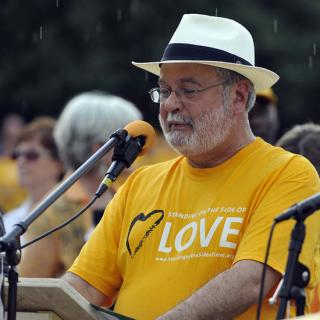 The Rev. Peter Morales began to speak at the public witness event, 'Standing on the Side of Love with LGBT People Everywhere!' as the rain began to fall.
