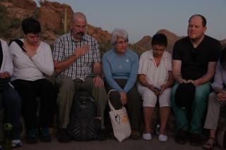 A group of UUs on a Borderlinks justice trip sit in a circle, praying as the light fades.