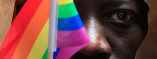 An asylum seeker from Uganda covers his face with a paper bag in order to protect his identity as he marches with the LGBT Asylum Support Task Force during the Gay Pride Parade in Boston