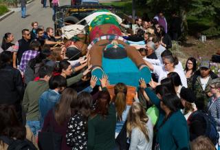 Indigenous and non-Indigenous allies bless the hand-carved totem pole during the 2014 journey
