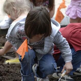 512px-A_young_girl_uses_a_trowel_to_dig_a_hole_for_plants_in_the_pollinator_garden wiki_commons