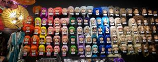 Rows and rows of brightly colored wigs, arranged in a rainbow