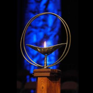 Photo of a lit chalice against a blue background