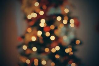 An out-of-focus shot of a christmas tree with small white lights.