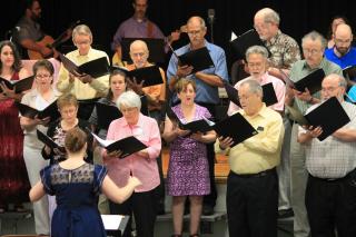 Choir members on risers, singing at UU Congregation of Fairfax, VA.
