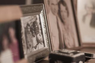 A line of framed family photos, all on a surface, some out of focus