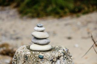 A stack of five stones on top of a larger rock.