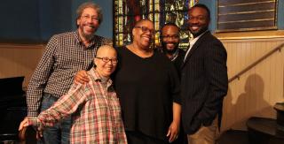 A group of UU religious professionals from diverse ethnic, religious, and cultural backgrounds smiles together.