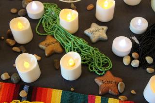 Candles, rocks, fabric and beads are seen in an up-close picture of an altar.
