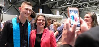 A young adult worship leader poses with UUA President Susan Frederick-Gray for a cell phone picture.