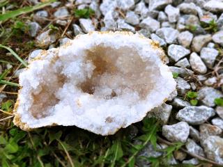 An open geode, crystalline edges glimmering, on the ground.