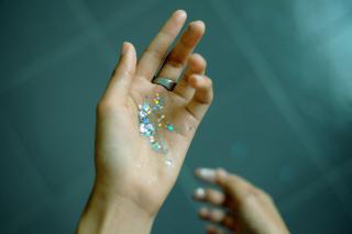In an outstretched palm, star-shaped glitter sparkles