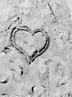 black and white photo of heart drawn in sand