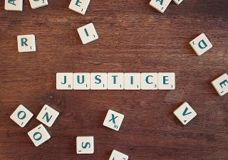 Scrabble-like tiles spelling out the word "justice"