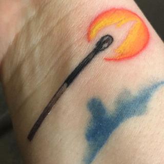 A color tattoo, on Sean Dennison's inner wrist, of a match with flame.