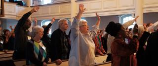 Attendees of Mosaic Makers conference raise hands into air during worship