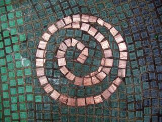Image of small tiles in a mosaic, forming a spiral.